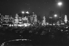 851276 Gezicht over het Vredenburg te Utrecht bij avond, met veel geparkeerde auto's en feestverlichting, vanuit het ...